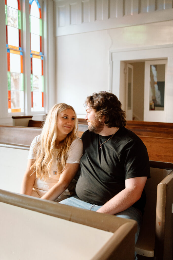 Couple in old chapel for engagement photos at sunset. Golden hour engagement photos